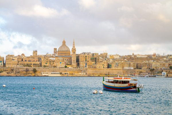 A beautiful sunset view of historic sites by the river in Valletta, Malta
