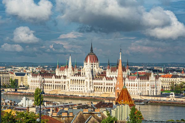 An aerial shot of Hungarian Parliament Building in Budapest, Hungary under a cloudy sky