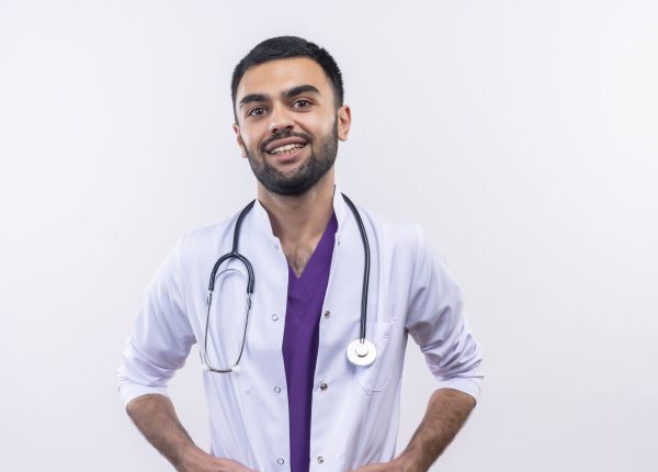 looking at camera smiling young male doctor wearing stethoscope medical gown on isolated white background