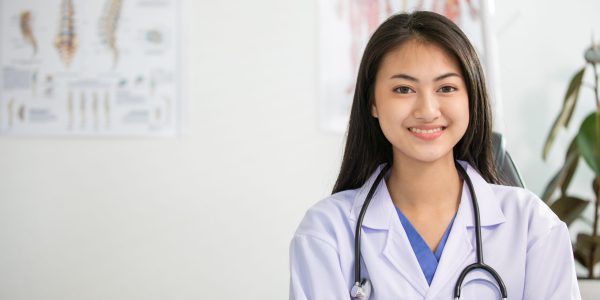 Young woman doctor smiling and working at office